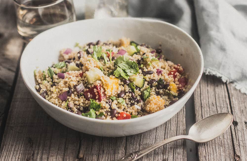 Salade de quinoa, mangue et haricots noirs dans un bol blanc