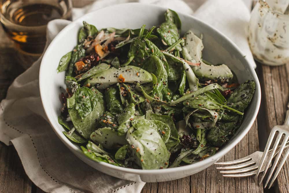 Salade d'épinards aux canneberges dans un bol blanc