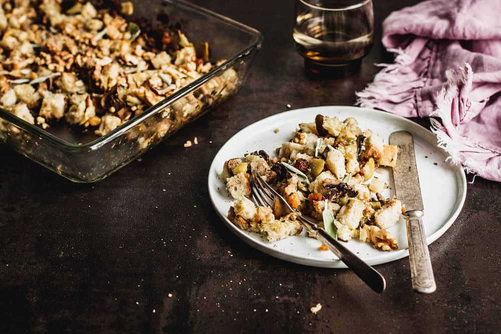 Vegan stuffing on a salad plate with the stuffing's casserole dish in the background