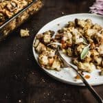 Vegan stuffing on a salad plate with the stuffing's casserole dish in the background