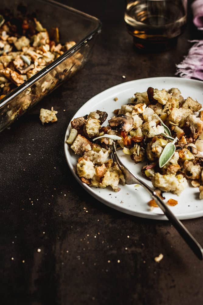 Vegan stuffing on a salad plate with the stuffing's casserole dish in the background