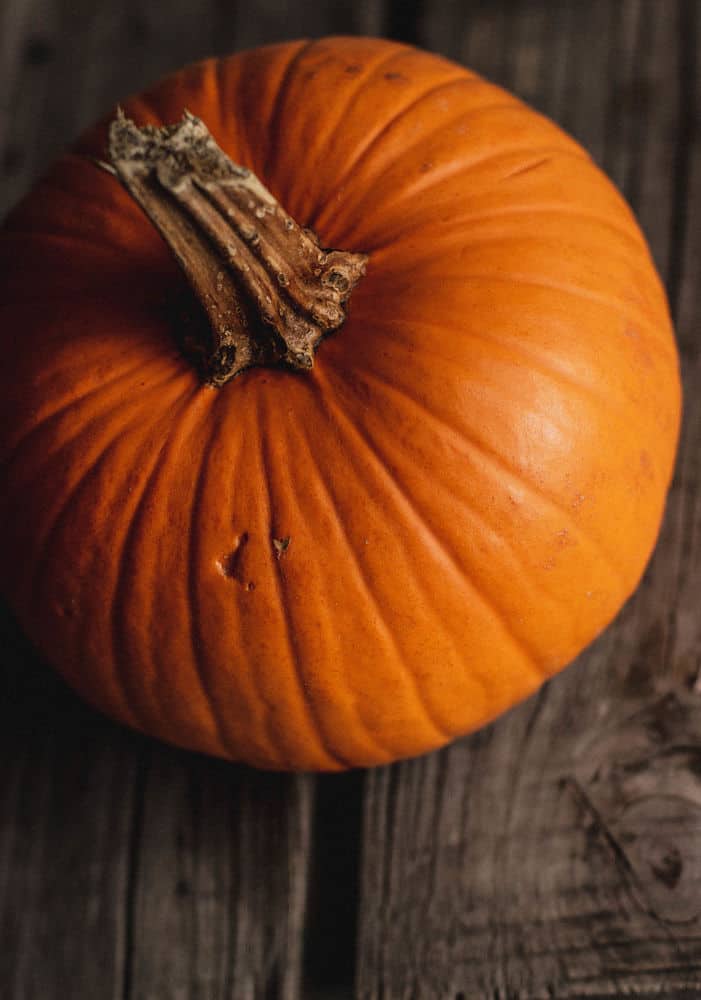 Bird's eye view of a small pumpkin sitting on a wooden board