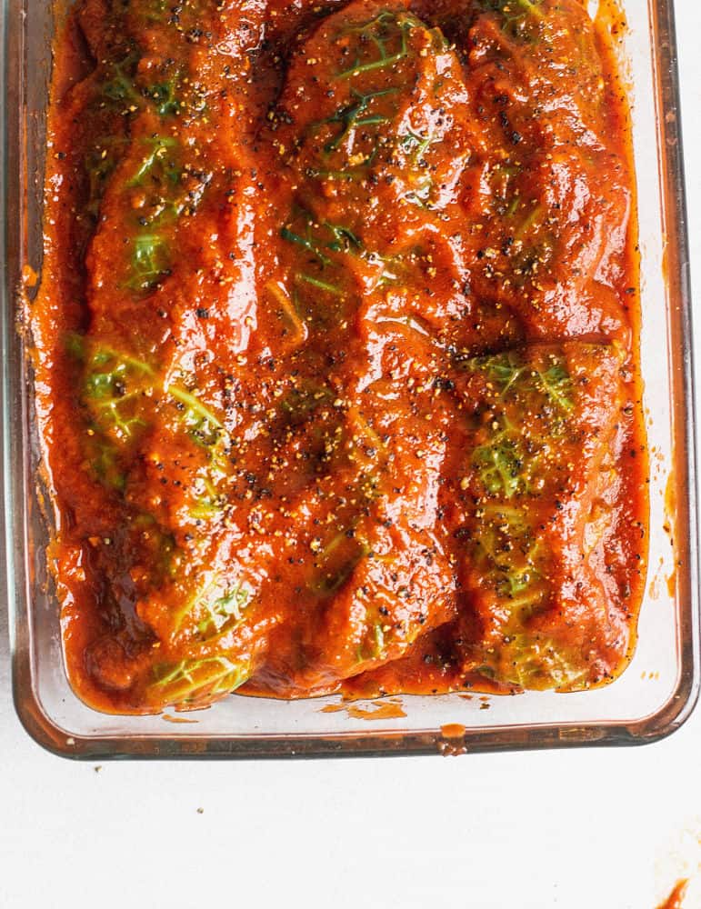 Bird's eye view of casserole dish with stuffed cabbage rolls topped with tomato sauce