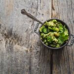 Cumin Guacamole with sliced jalapeno in a small pot on a wooden board