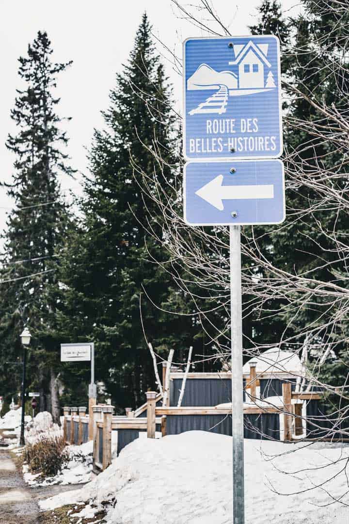 Showing a sign that says Route des belles-histoires