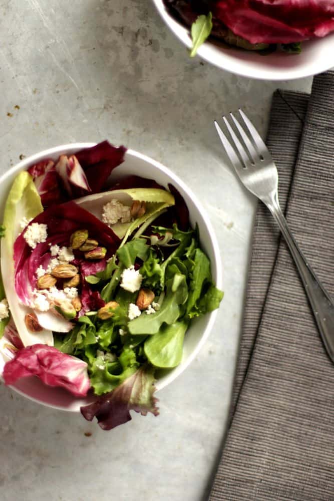 Top view of two bols of radicchio and endive salad with pistachios and almond ricotta