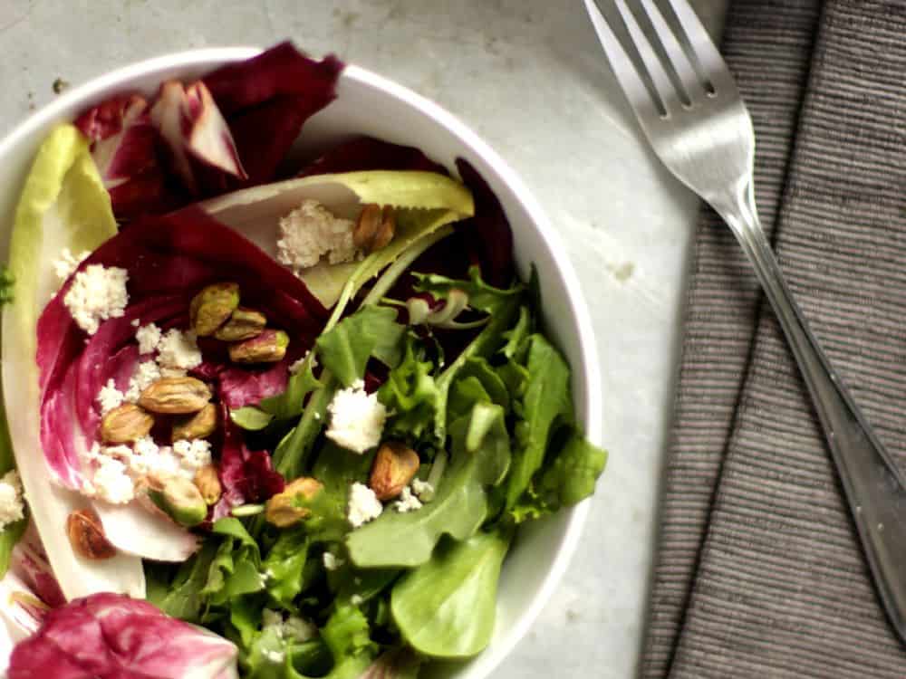 Top view of two bols of radicchio and endive salad with pistachios and almond ricotta