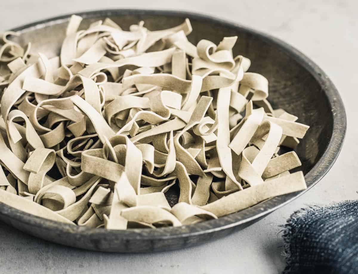 Dry pasta ribbons in a shallow metallic plate