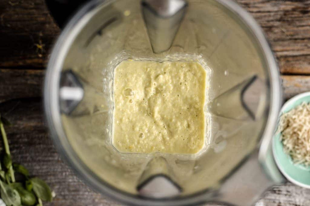 Overhead view of puréed corn in a pot of a blender
