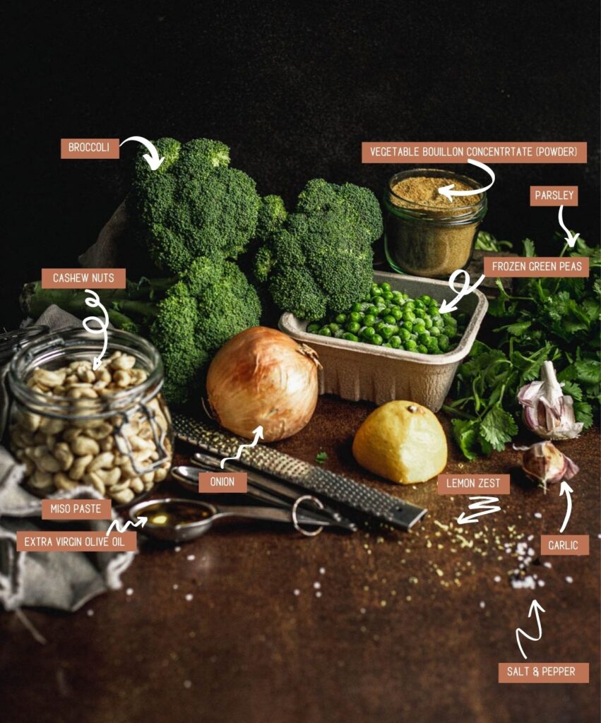 Ingredients for the broccoli and pea soup (clockwise): broccoli, peas in a small square container, powdered vegetable broth in a small glass jar, a bunch of parsley, cloves of garlic, half a lemon, lemon zest, onion, olive oil and miso in a set of spoons and cashews in a small mason jar