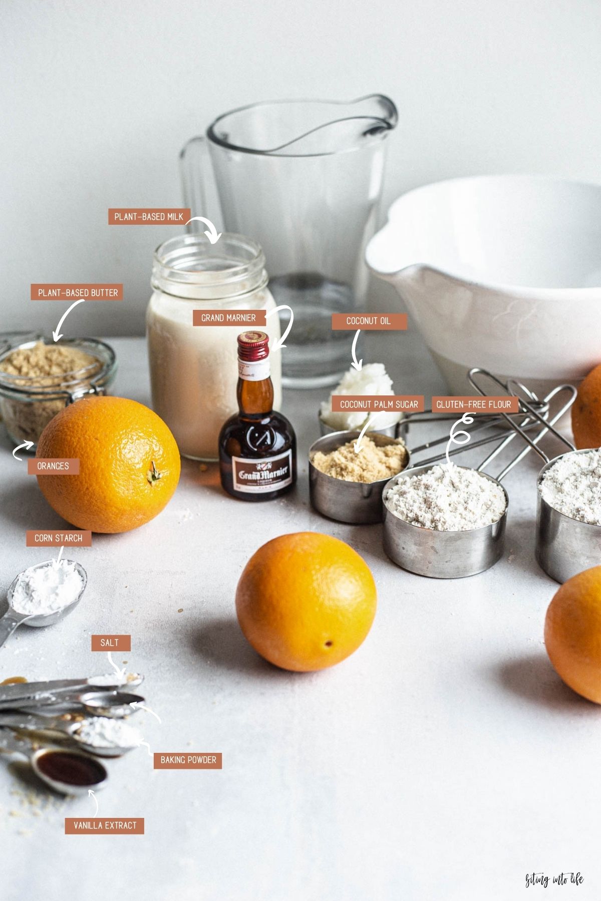 Aesthetically placed crêpe Suzette ingredients (clockwise): oranges, plant-based milk, Grand Marnier, coconut oil, coconut palm sugar, gluten-free flour, salt, baking powder, and vanilla extract