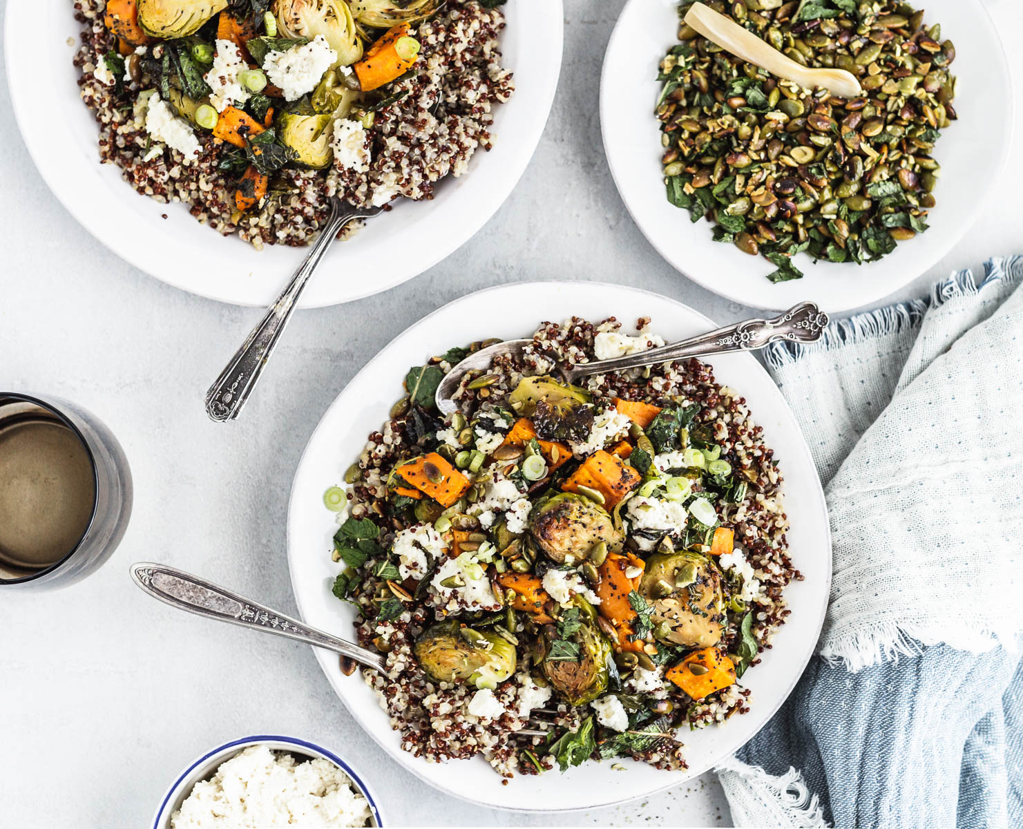 A plate of quinoa, Brussels sprouts, and sweet potato mixed with vegetable ricotta-style cheese 