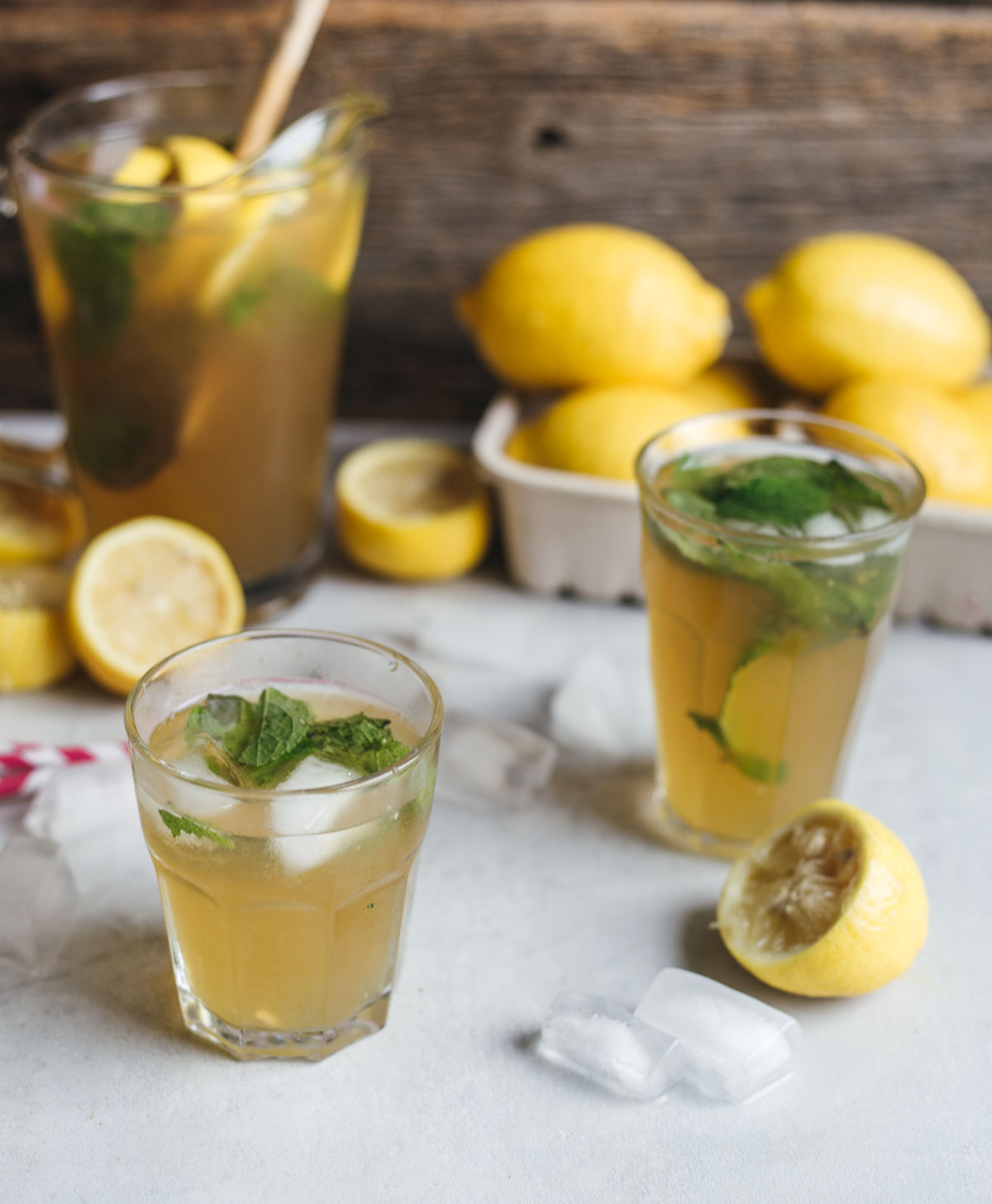 Two glasses of lemonade garnished with mint on a surface