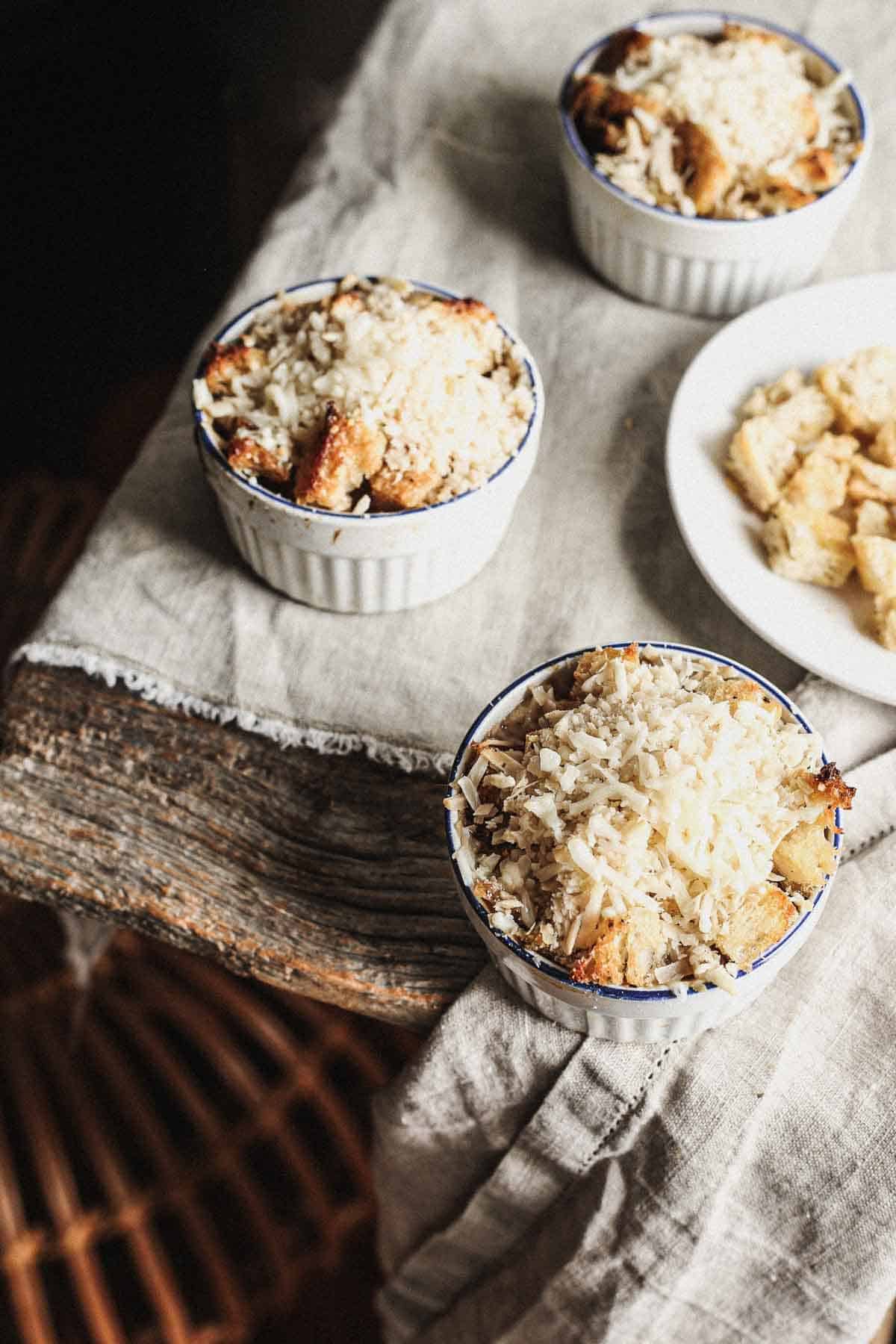 A bowl of vegan onion soup with bread and cheese on top.