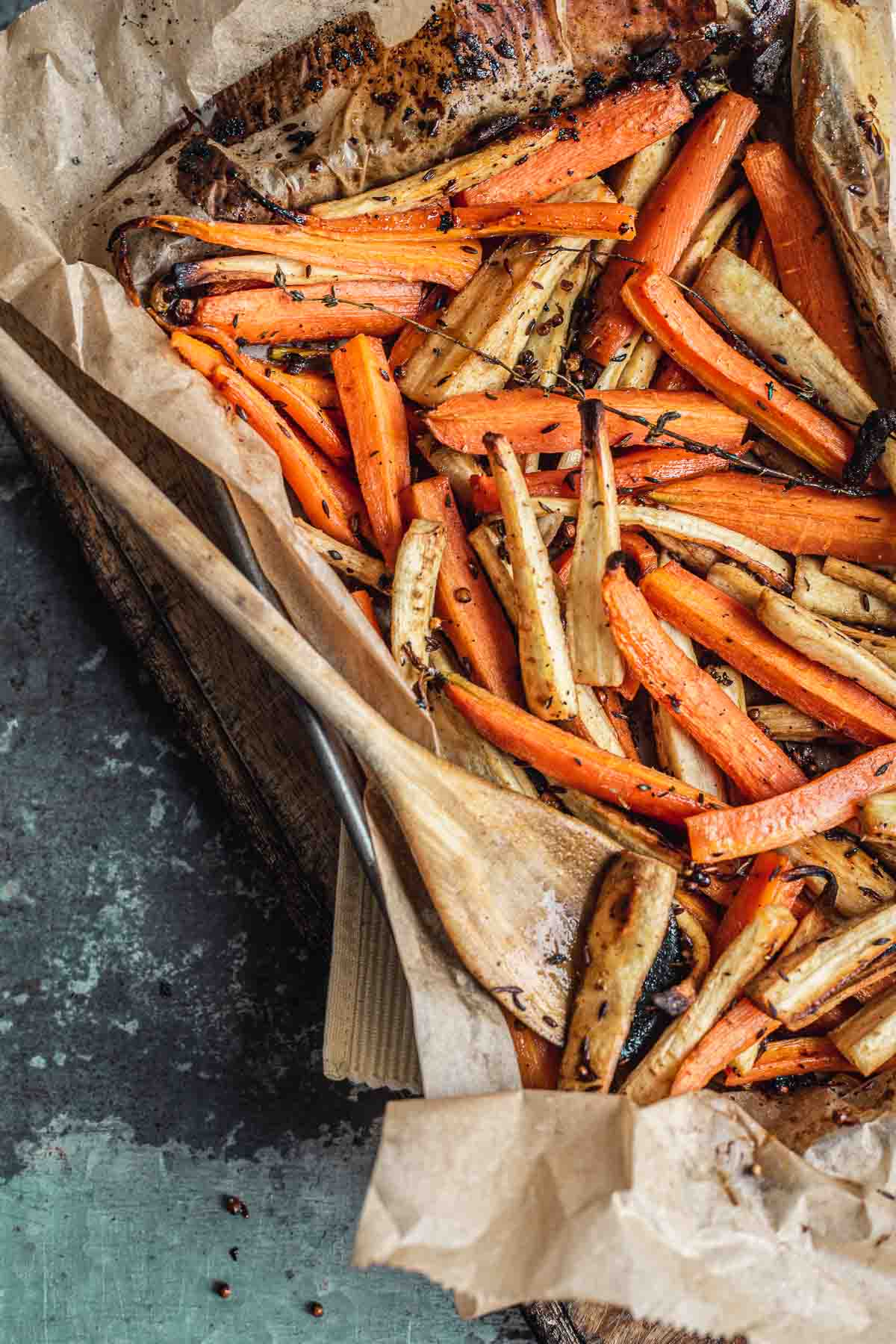 Honey-roasted carrots and parsnips on a baking sheet.