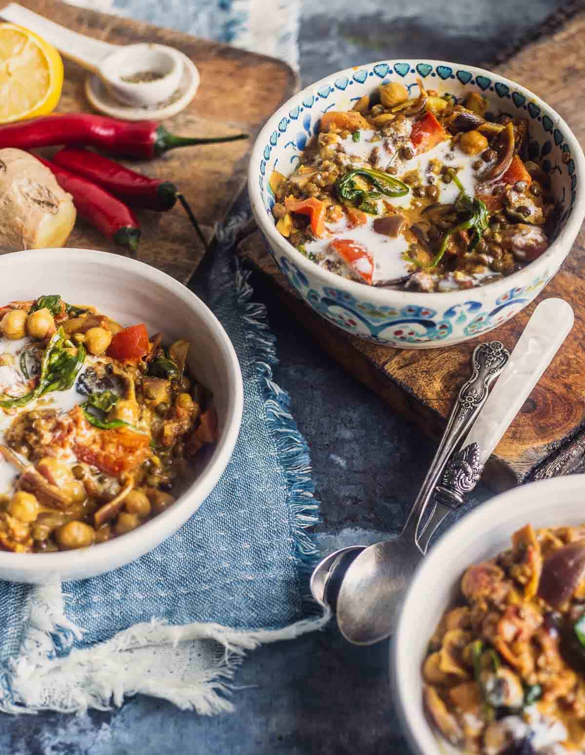 Three bowls of cream chickpea lentil coconut curry.