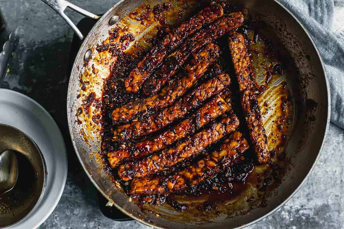 Tempeh cooking in a thickened sauce.  