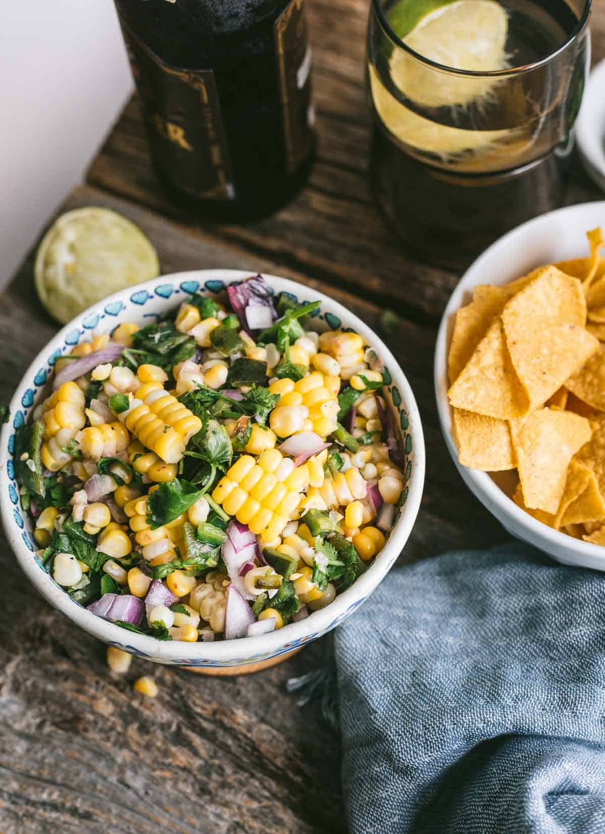 Chipotle copycat corn salsa in a bowl next to a bowl of tortilla chips.